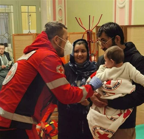 Red Cross medic in Poland helping a family newly arrived from Ukraine